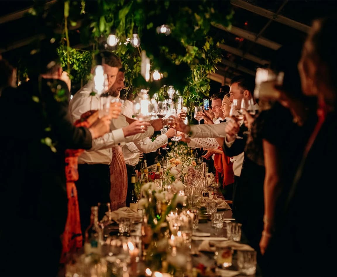Wedding guests toast to newlywed couple with celebratory drink