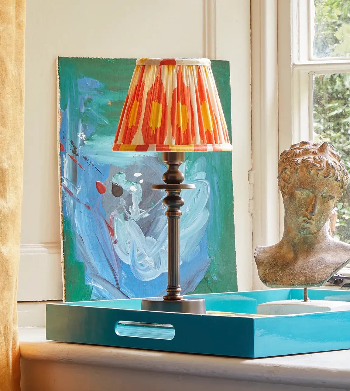 Pooky Phileas rechargeable lamp with orange shade on a tray