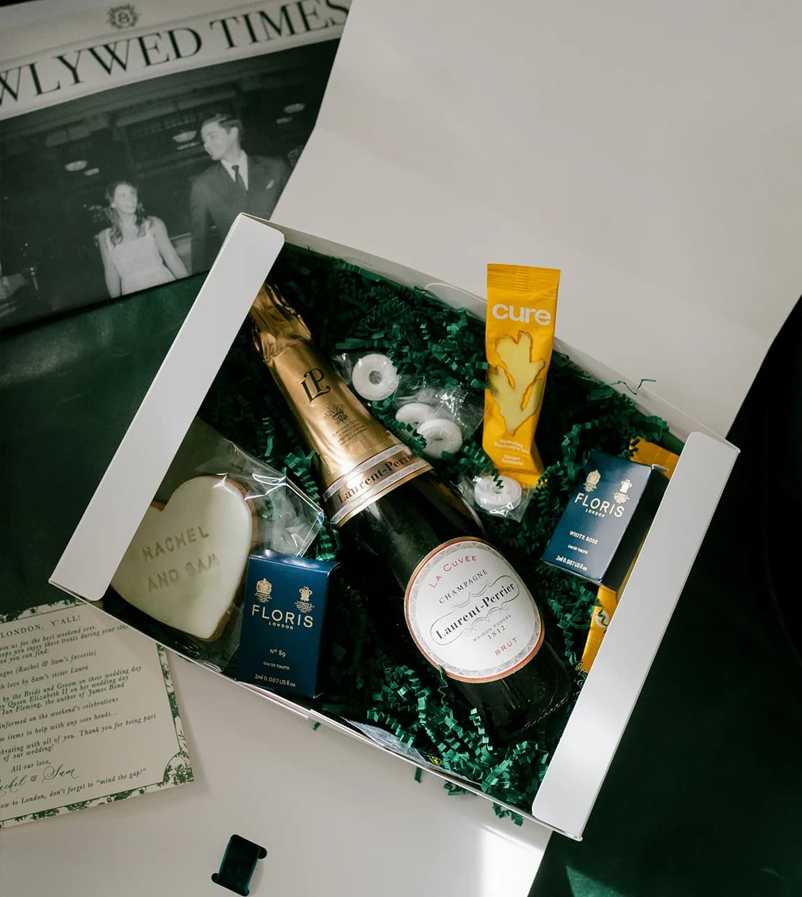 A luxury wedding gift box for guests with Laurent Perrier champagne, candies, custom biscuit and wedding newspaper