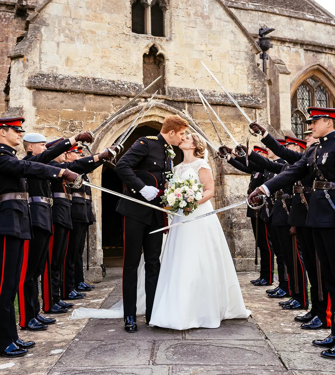 Bride and groom walk outside the church, through the saber arch after, their military wedding ceremony 