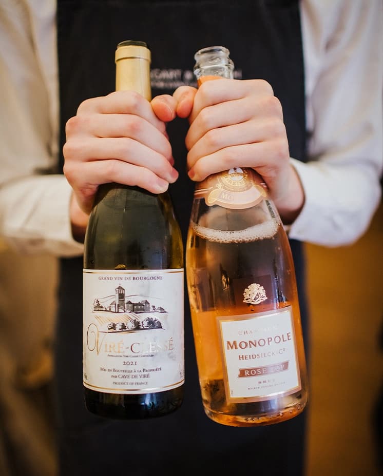 Caterer holding bottles of white and rose wine