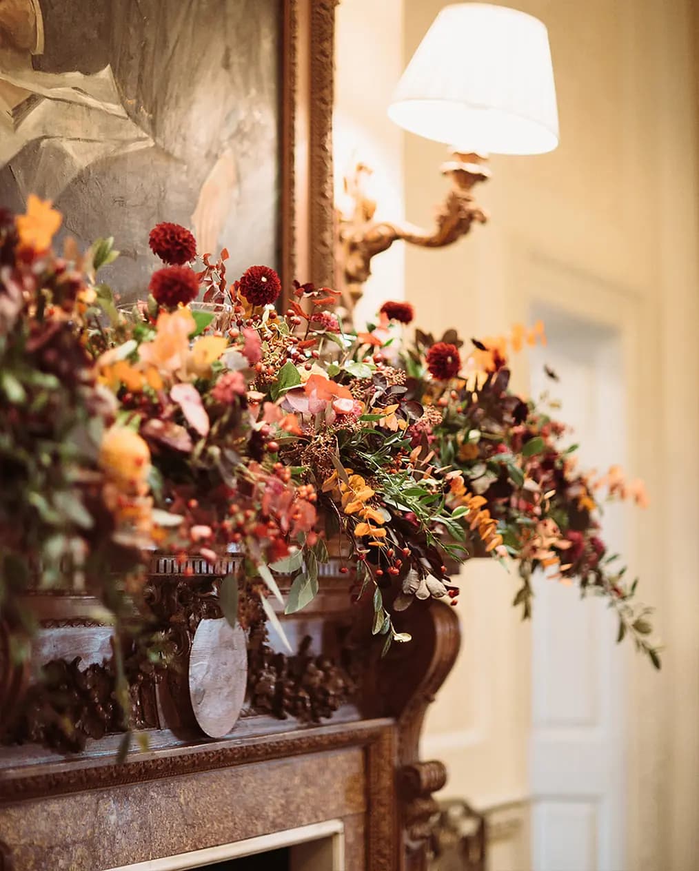 An autumn wedding flower arrangement on wooden fireplace mantelpiece