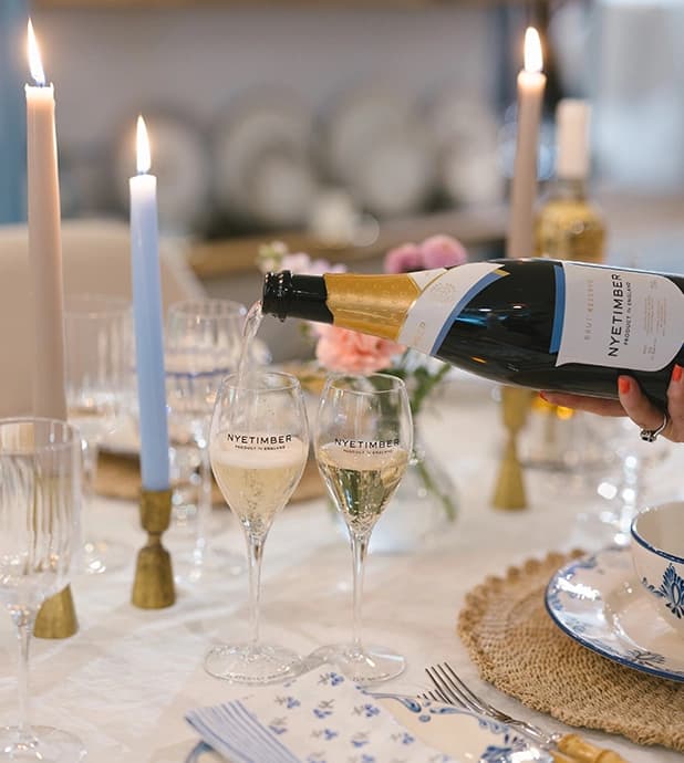 Nyetimber sparkling wine being poured into glasses on the beautifully set table in The Wedding Present Company showroom