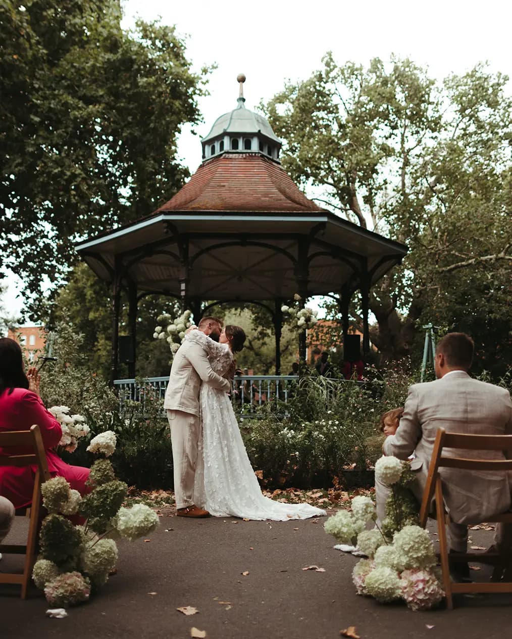 Bride and groom kiss during their wedding ceremony at Myatt's Field Park,