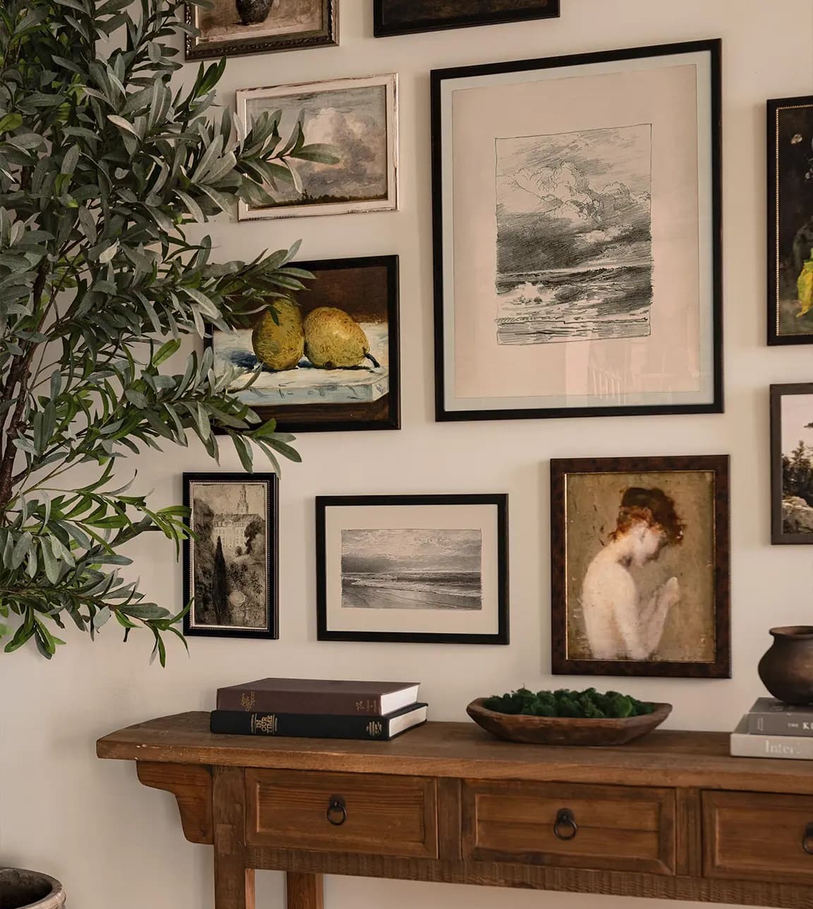 A gallery wall with mismatched frames is placed above a wooden console.